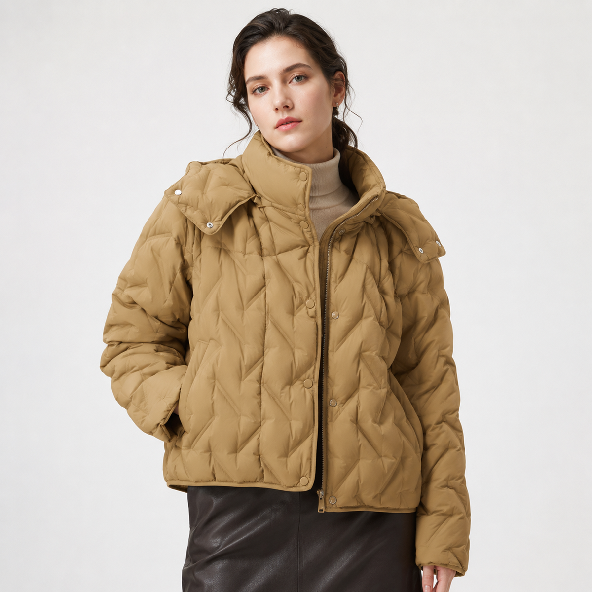 Woman wearing a camel women's hooded puffer jacket in a clean studio front three-quarter view