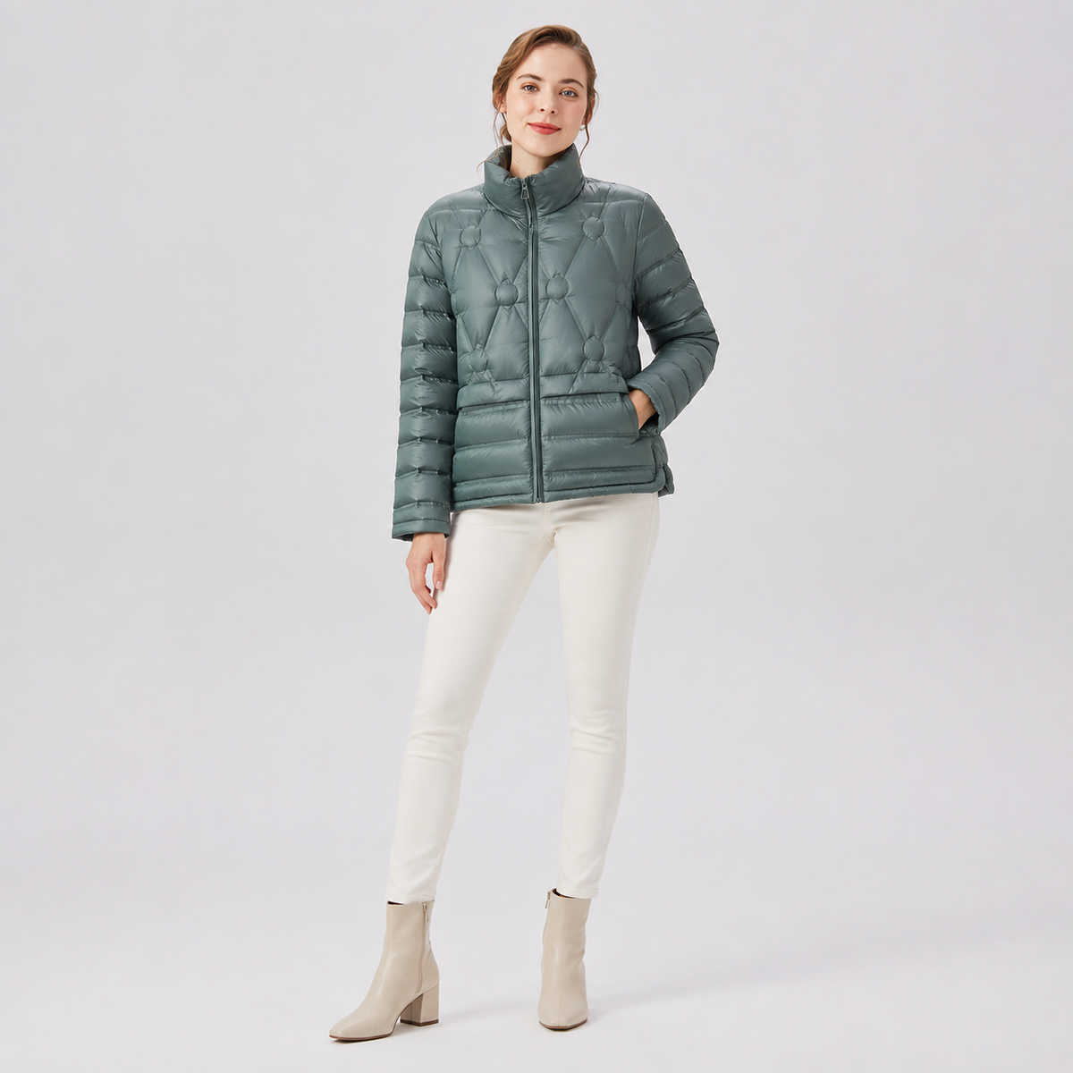 Model wearing a sage green women's short puffer jacket in a clean alternate full-body studio pose