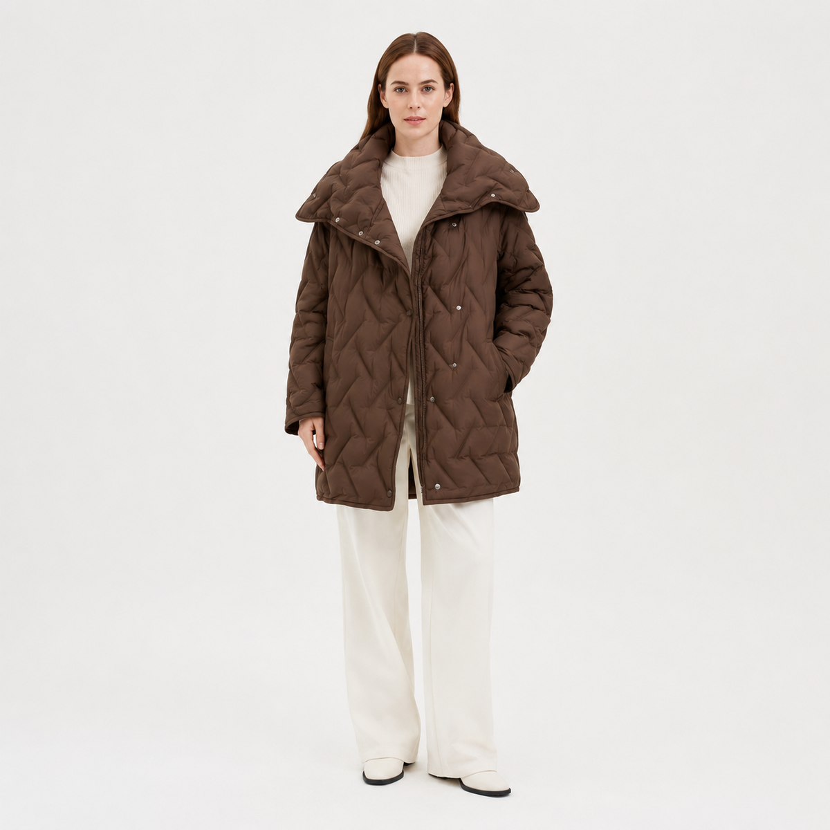 Model wearing a brown women's diamond-quilted mid-length puffer jacket in a clean full-body studio view
