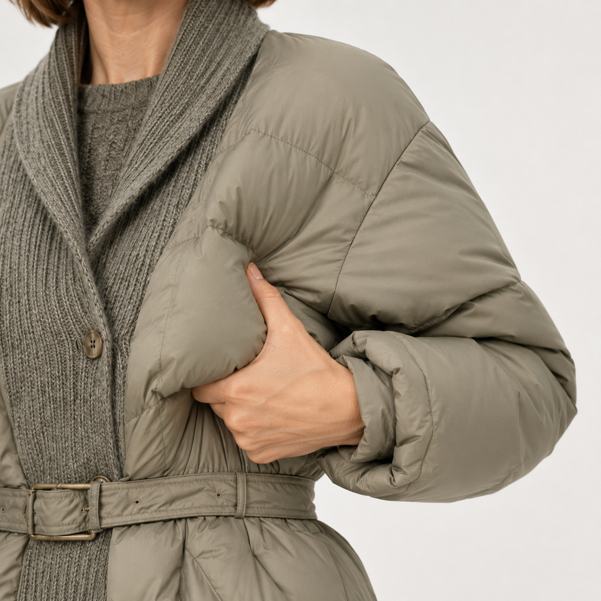 Close-up of side pocket, sleeve and quilted body on the taupe women's belted puffer jacket