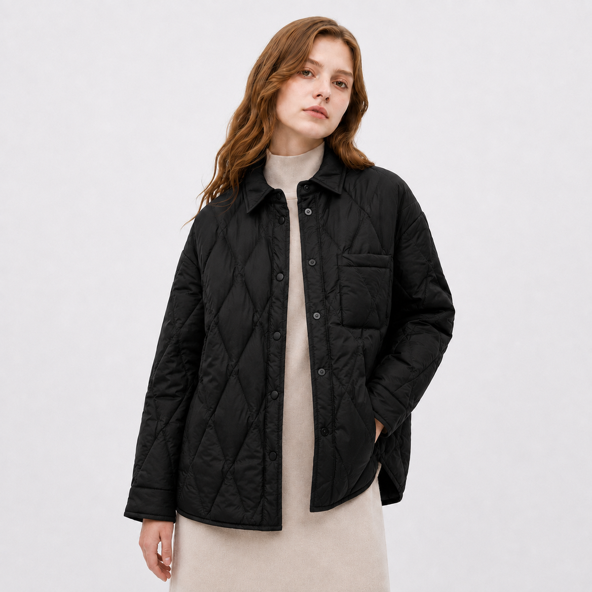 Model wearing a black women's diamond-quilted shirt jacket in a clean upper-body studio front view