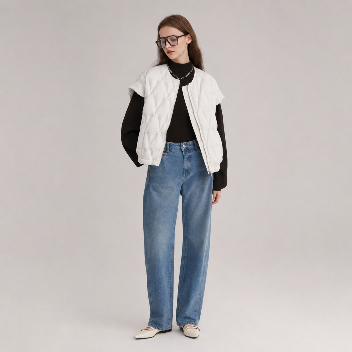 Model wearing a ivory women's layered quilted vest jacket in a clean full-body studio view over black top and jeans