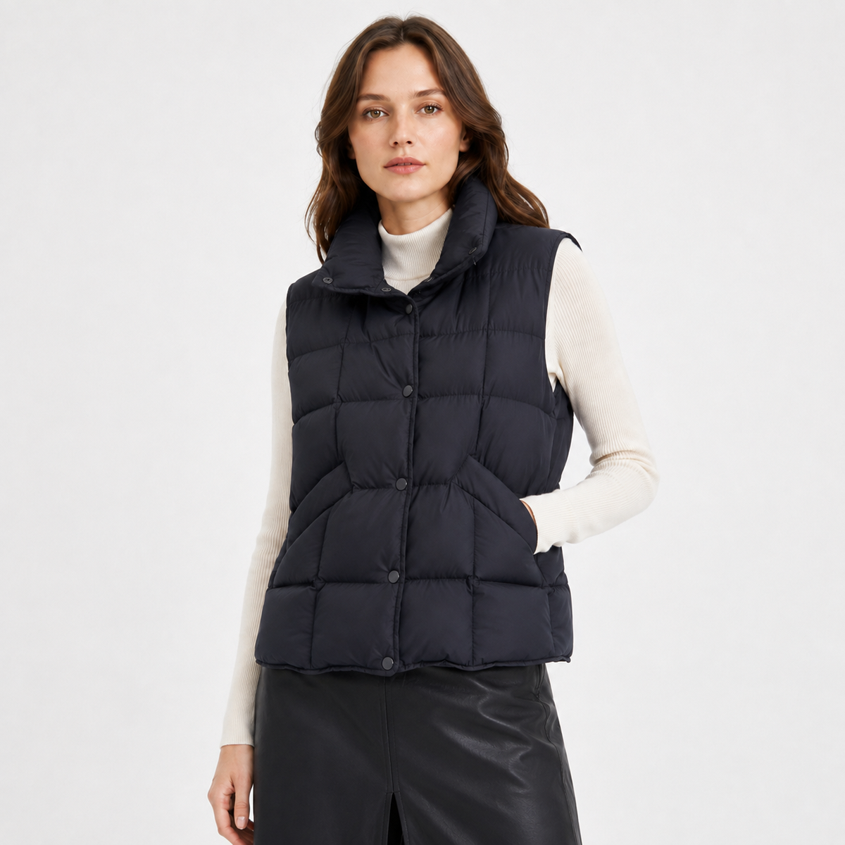 Model wearing a navy women's high-collar puffer vest in a clean front studio view