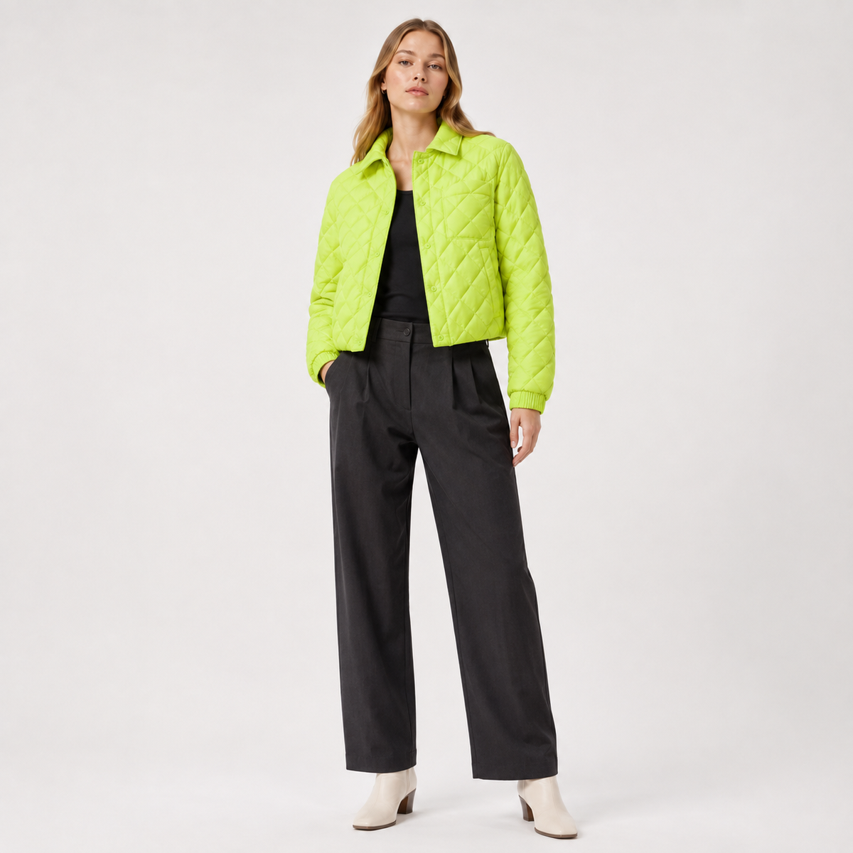 Model wearing a neon green women's collarless quilted jacket in a clean full-body studio view